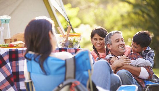 Family Enjoying Camping Holiday In Countryside